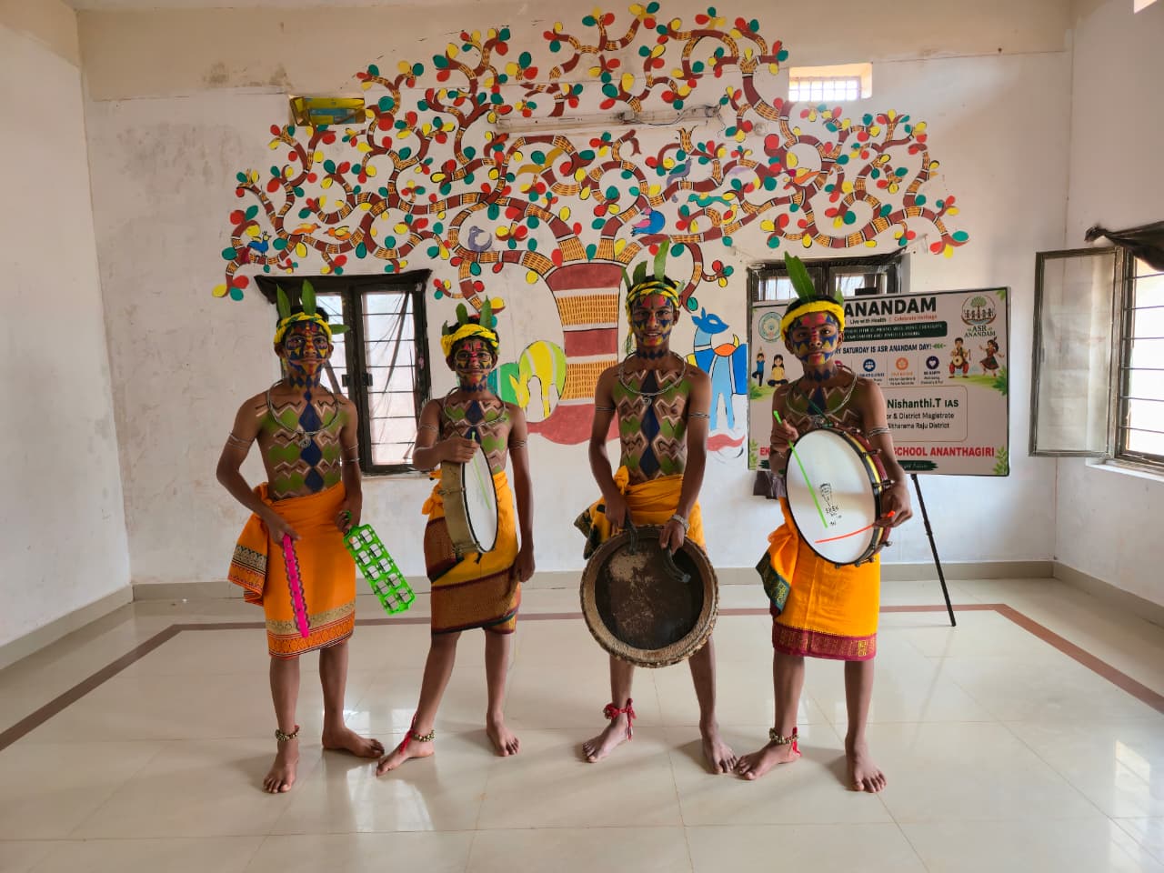 EMRS Ananthagiri students in traditional tribal attire performing with drums at the Cultural Fest in Araku