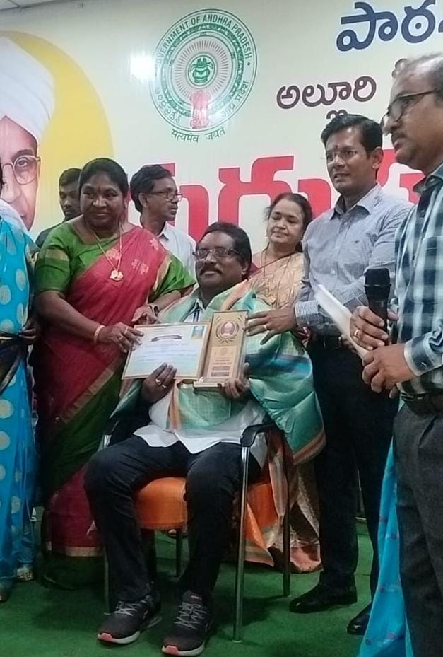 Principal of EMRS Ananthagiri receiving the District Best Principal Award from district officials